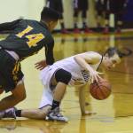 Homer&rsquo;s Daniel Reutov slips while dribbling the ball with pressure from Service&rsquo;s Brandon Gail (14) Dec. 15, 2017, at the Powerade/Al Howard Tip-Off tournament at Soldotna High School. (Photo by Joey Klecka/Peninsula Clarion)
