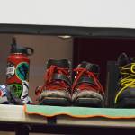 Ski boots line a table during a backcountry skiing presentation by Tony Doyle and Trent Sexton, Dec. 20 at the Kenai Visitors and Cultural Center. (Photo by Joey Klecka/Peninsula Clarion)