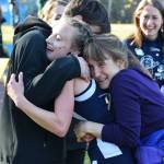 Division II girls winner Autumn Daigle (center) receives hugs from her brother and mother Ann (right) Sept. 30, 2017, at the ASAA First National Bank Alaska Cross-Country State Championships at Bartlett High School. (Photo by Joey Klecka/Peninsula Clarion)