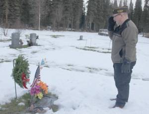 John Walker, Commander Jerry V. Horn Memorial Post 10046 VFW places a wreath on a veteran&rsquo;s grave in Soldotna.