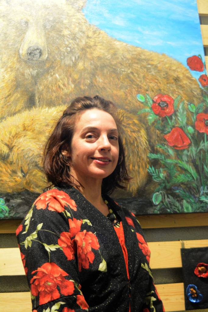 Artist Julianne Tomich stands next to one of her bear paintings at the First Friday opening of her show at Grace Ridge Brewery. (Photo by Michael Armstrong, Homer News)