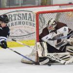 Coulee Region forward Connor Szmul (left) attempts to slip the puck by Kenai River goaltender Gavin Enright Friday night at the Soldotna Regional Sports Complex. (Photo by Joey Klecka/Peninsula Clarion)
