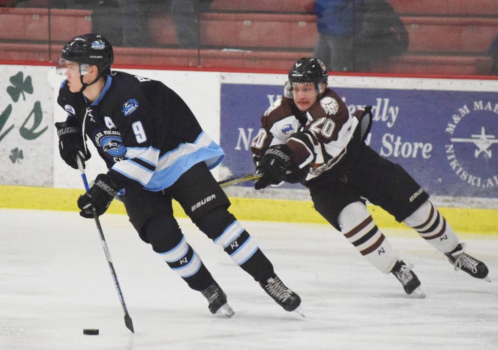 Kenai River forward Tyler Miknich (right) tries to get a stick on Coulee Region defenseman Marshal Plunkett Friday night at the Soldotna Regional Sports Complex. (Photo by Joey Klecka/Peninsula Clarion)