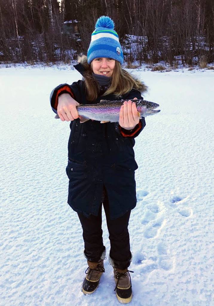 Kat Sorensen, author of the article, is shown holding a rainbow trout caught while ice fishing on Spirit Lake near Kenai, Alaska on Dec. 26, 2017. (Photo by Kat Sorensen/Peninsula Clarion)
