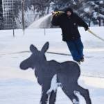 A Soldotna Parks & Recreation worker sprays a layer of water to be frozen into a skating rink Thursday at Soldotna Creek Park. (Photo by Joey Klecka/Peninsula Clarion)