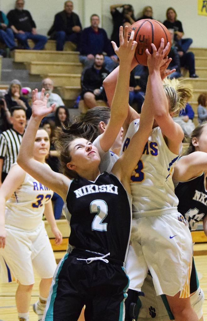 Nikiski sophomore America Jeffreys (2) works for a rebound against Monroe&rsquo;s Grace Hodges Friday night at the Rus Hitchcock Nikiski Tip-Off Tournament in Nikiski. (Photo by Joey Klecka/Peninsula Clarion)