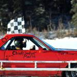 A winning racecar driver takes a victory lap on the ice track atop a frozen lake at the Decanter Inn on Sunday, Jan. 22, 2018 in Kasilof, Alaska. Every Sunday in the winter, the Decanter Inn hosts Peninsula Ice Racing events for drivers to try their hand at the frozen track on the shallow lake at the bottom of the hill behind the inn. The racers can use studded tires on their front wheels only and equip the sides of their vehicles with bumpers as other vehicles are likely to slip and slide into them. Spinning out is common. A tow truck waits on the sidelines to retrieve drivers who get stuck on the berms alongside the track. Fans gathered Sunday despite the cold to cheer the racers on. The men race in the morning, followed by the women&rsquo;s races in the afternoon. (Photo by Elizabeth Earl/Peninsula Clarion)