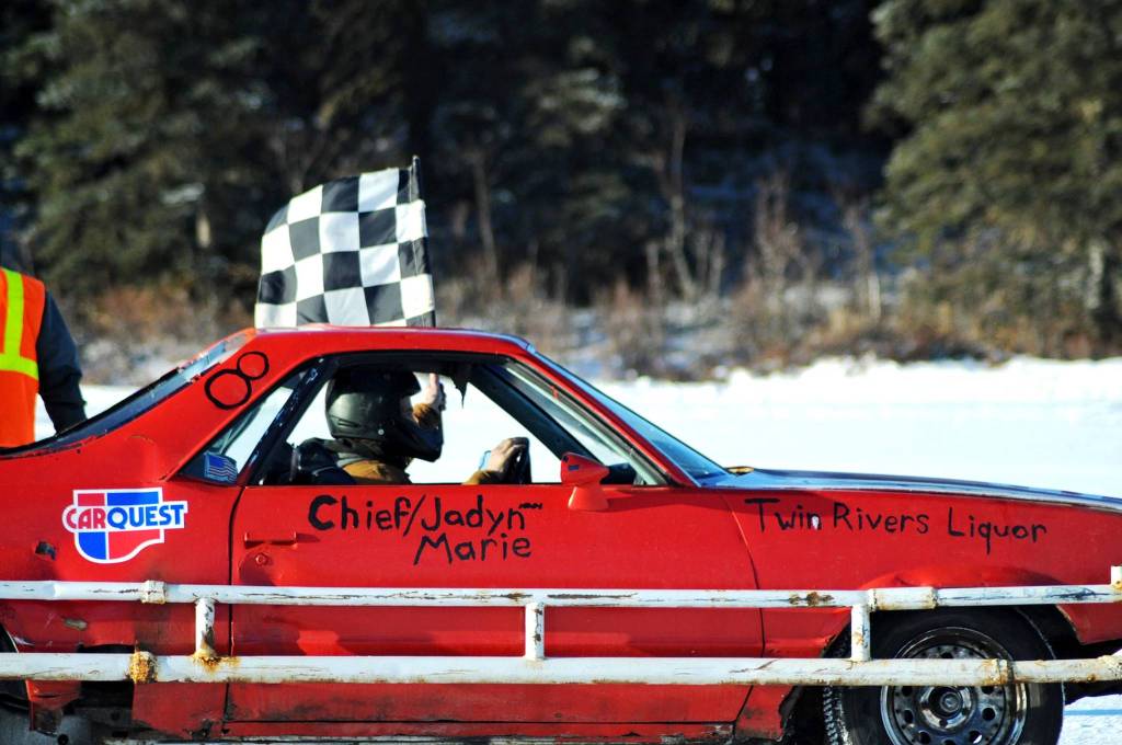 A winning racecar driver takes a victory lap on the ice track atop a frozen lake at the Decanter Inn on Sunday, Jan. 22, 2018 in Kasilof, Alaska. Every Sunday in the winter, the Decanter Inn hosts Peninsula Ice Racing events for drivers to try their hand at the frozen track on the shallow lake at the bottom of the hill behind the inn. The racers can use studded tires on their front wheels only and equip the sides of their vehicles with bumpers as other vehicles are likely to slip and slide into them. Spinning out is common. A tow truck waits on the sidelines to retrieve drivers who get stuck on the berms alongside the track. Fans gathered Sunday despite the cold to cheer the racers on. The men race in the morning, followed by the women&rsquo;s races in the afternoon. (Photo by Elizabeth Earl/Peninsula Clarion)
