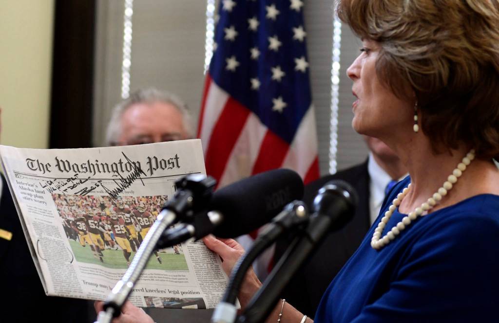 Sen. Lisa Murkowski, R-Alaska, holds up a copy of a news paper with a note from President Donald Trump during an event in her office on Capitol Hill in Washington, Monday, Jan. 22, 2018. Murkowski was joined by other Alaskan officials regarding the Interior Department&rsquo;s decision to the construction of a road through a national wildlife refuge in Alaska.The road would connect the communities of King Cove and Cold Bay, which has an all-weather airport needed for emergency medical flights. (AP Photo/Susan Walsh)