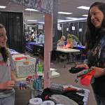 Aleea Faulkner, 12, shares socks with mom Wausaumoutouikwe Sandman-Shelifoe on Wednesday, Jan. 24 during Project Homeless Connect at the Soldotna Sports Complex. Faulkner spearheaded a sock drive to support the annual community service event. (Photo by Erin Thompson/Peninsula Clarion)