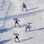 A group of skiers race up a hill late in the boys varsity race Friday afternoon in the Kenai Klassic races at the Tsalteshi Trails in Soldotna. (Photo by Joey Klecka/Peninsula Clarion)