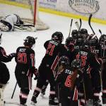 The Kenai Central hockey team celebrates Levi Mese&rsquo;s overtime goal that gave the Kardinals a 6-5 win over Soldotna on Saturday night at the Soldotna Regional Sports Complex. (Photo by Joey Klecka/Peninsula Clarion)