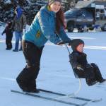 Donna Edmunds, of Soldotna, pushes her son Lucas on a ski buggy during the annual Peninsula Winter Games, which returned to Soldotna for the forty second year on Saturday at the Soldotna Regional Sports Complex. The event offered an array of children&rsquo;s events and activities, including a Monopoly tournament, an outdoor film, free lunch and a carnival. The Kenai Peninsula Hockey Association also held an invitational hockey tournament during the event. (Photo by Kat Sorensen/Peninsula Clarion)