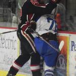 Kenai Central skater Nate Beiser (15) checks Palmer&rsquo;s Pierce Brooks into the boards Thursday evening in a North Star Conference tournament semifinal at the Soldotna Regional Sports Complex. (Photo by Joey Klecka/Peninsula Clarion)