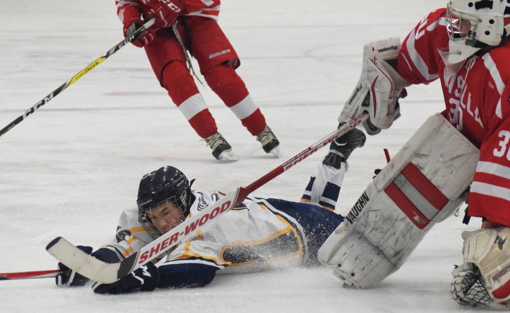Homer&rsquo;s Tim Blakely slides into Wasilla goaltender Aaron Campbell Friday in a North Star Conference tournament semifinal at the Soldotna Regional Sports Complex. (Photo by Joey Klecka/Peninsula Clarion)