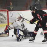 Kenai Central skater Levi Mese (5) watches as the puck nearly slips by Colony goalie Cole Doss, Friday in a North Star Conference tournament semifinal at the Soldotna Regional Sports Complex. (Photo by Joey Klecka/Peninsula Clarion)