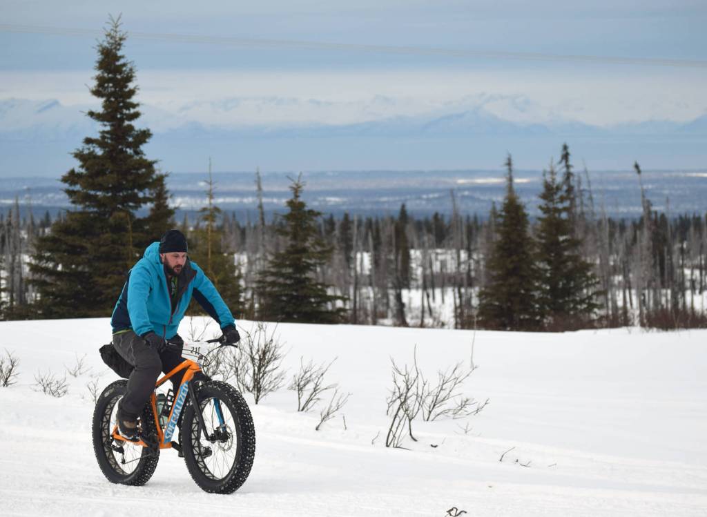Joel Todd crests a hill during Fat Freddie&rsquo;s Bike Race and Ramble on Saturday, Feb. 10, 2018, in the Caribou Hills. (Photo by Jeff Helminiak/Peninsula Clarion)