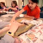 Alana Mckinley pokes inside a salmon during a dissection presentation at the Connections Homeschool offices in Soldotna led by Alaska Department of Fish and Game as part of the Salmon in the Schools program. (Photo by Kat Sorensen/Peninsula Clarion)