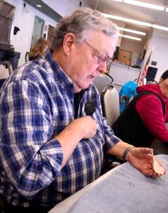 Del Otter leads a whittling lesson at the Kenai Senior Center in Kenai on Tuesday, guiding a class through the basics of carving a small bird magnet. (Photo by Kat Sorensen/Peninsula Clarion)