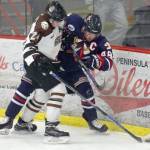 Kenai River Brown Bears forward Zach Krajnik, of Eagle River, and Cade Groton of the Johnstown (Pennsylvania) Tomahawks battle for the puck Friday, Feb. 16, 2018, at the Soldotna Regional Sports Complex. (Photo by Jeff Helminiak/Peninsula Clarion)
