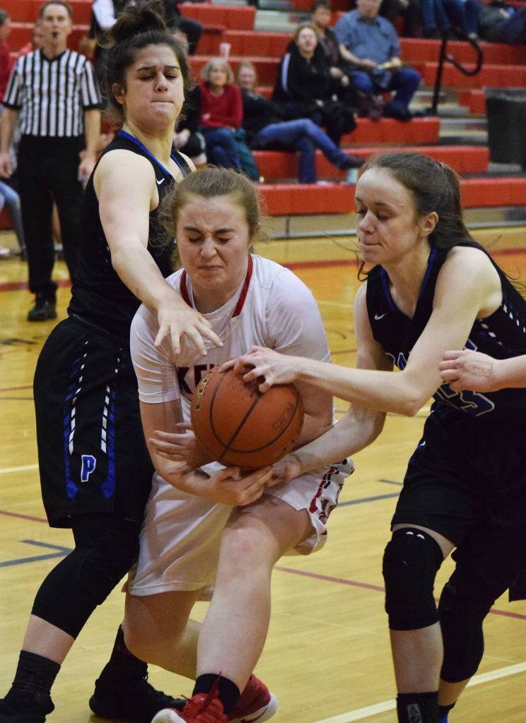 Kenai&rsquo;s Liz Hanson shoots between Palmer defenders Kassidy Bowman (right) and Sophia Benshelter, Friday night at Kenai Central High School. (Photo by Joey Klecka/Peninsula Clarion)