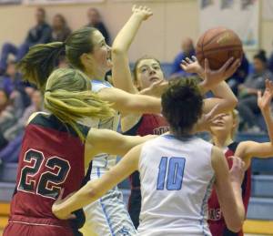 Soldotna&rsquo;s Danica Schmidt squeezes between Juneau-Douglas&rsquo; Caitlin Pusich and Cassie Dzinich for a shot Friday, Feb. 23, 2018, at Soldotna High School. (Photo by Jeff Helminiak/Peninsula Clarion)