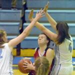 Kiana Potter of Juneau-Douglas drives between Soldotna&rsquo;s Kiana Holland and Mei Miller on Thursday, Feb. 23, 2018, at Soldotna High School. (Photo by Jeff Helminiak/Peninsula Clarion)