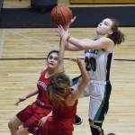 Nikiski&rsquo;s Bethany Carstens drives for a layup over ACS defenders Mary Kate Parks (middle) and Jessie Davis Friday at Nikiski High School. (Photo by Joey Klecka/Peninsula Clarion)