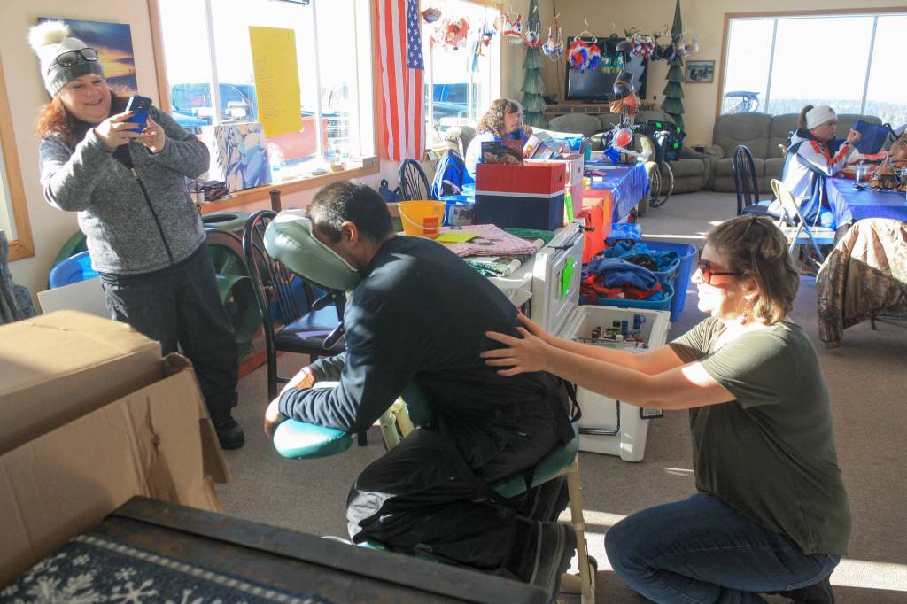 Massage therapist Angie Wellborn massages an attendee at the WOW fundraiser on Saturday, Feb. 24, 2018 near Ninilchik, Alaska. Wellborn donated her tips to the event, and half of any prepaid $60 massage booked at the event. (Photo by Erin Thompson/Peninsula Clarion)
