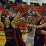 Kenai&rsquo;s Brooke Satathite (white jersey) is swarmed by Juneau&rsquo;s Kiana Potter (5) and Caitlin Pusich (22) while fighting for a rebound Saturday at Kenai Central High School. (Photo by Joey Klecka/Peninsula Clarion)