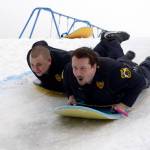 Patrol Officer Josh Hall, left, and School Resource Officer Dan Smith take a turn sledding down the Olympic course set up for the Boys and Girls Club&rsquo;s Police Athletic League (P.A.L.) Club in Kenai on Monday. The club is a sports-oriented opportunity for youth and law enforcement to interact and organizers set-up an Olympics inspired day where the kids competed for medals in different winter activities. (Photo by Kat Sorensen/Peninsula Clarion)
