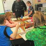 Soldotna Police Officer Tobin Brennan discusses a lesson with a student during a D.A.R.E. class at Soldotna Elementary School on Wednesday, Feb. 18. (Photo by Erin Thompson/Peninsula Clarion)