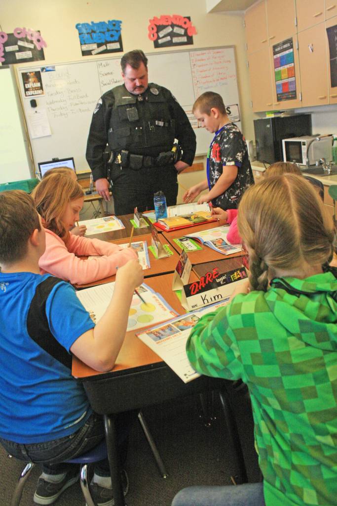 Soldotna Police Officer Tobin Brennan discusses a lesson with a student during a D.A.R.E. class at Soldotna Elementary School on Wednesday, Feb. 18. (Photo by Erin Thompson/Peninsula Clarion)
