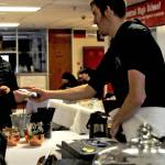 Tony Kaser helps a customer at the Hearth Eathery and Catering&rsquo;s stand during a craft fair fundraiser for the Central Peninsula Special Olympics at Kenai Central High School on Saturday, March 3, 2018 in Kenai, Alaska. The fair featured a number of artists and craftsmen selling work ranging from paintings to wooden toys to essential oils, with proceeds from the fair going to assist the Special Olympics in purchasing jerseys, equipment, transportation and training costs. The Central Peninsula Special Olympics coordinates sports programs for people with intellectual disabilities as a subprogram of the statewide Special Olympics. Kaser participates in swimming in the Special Olympics. (Photo by Elizabeth Earl/Peninsula Clarion)