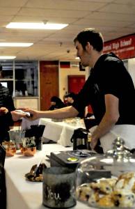 Tony Kaser helps a customer at the Hearth Eathery and Catering&rsquo;s stand during a craft fair fundraiser for the Central Peninsula Special Olympics at Kenai Central High School on Saturday, March 3, 2018 in Kenai, Alaska. The fair featured a number of artists and craftsmen selling work ranging from paintings to wooden toys to essential oils, with proceeds from the fair going to assist the Special Olympics in purchasing jerseys, equipment, transportation and training costs. The Central Peninsula Special Olympics coordinates sports programs for people with intellectual disabilities as a subprogram of the statewide Special Olympics. Kaser participates in swimming in the Special Olympics. (Photo by Elizabeth Earl/Peninsula Clarion)