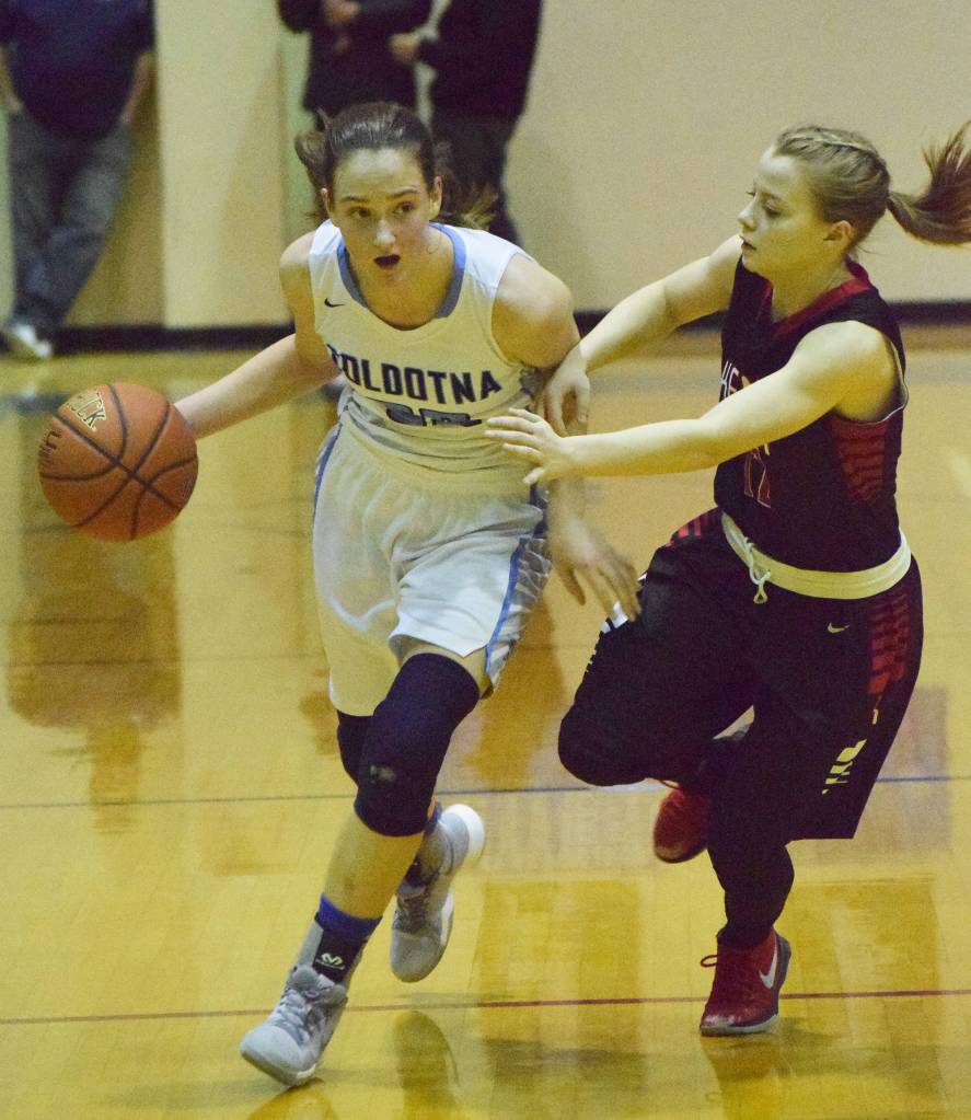 Soldotna&rsquo;s Danica Schmidt (left) looks for an open teammate with Kenai&rsquo;s Hayley Maw guarding her Saturday night at Soldotna High School. (Photo by Joey Klecka/Peninsula Clarion)