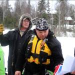 Mitch Osborne (back), owner of the Test the Waters dive shop in North Pole and an ice diving instructor, gives a safety briefing to members of the Nikiski Fire Department before an ice diving drill on Island Lake on Friday in Nikiski. The Nikiski Fire Department is working on getting its ice diving team up to certifications to perform operations on frozen lakes if need be, such as rescuing sunken cars or people or recovering evidence. (Photo by Elizabeth Earl/Peninsula Clarion)