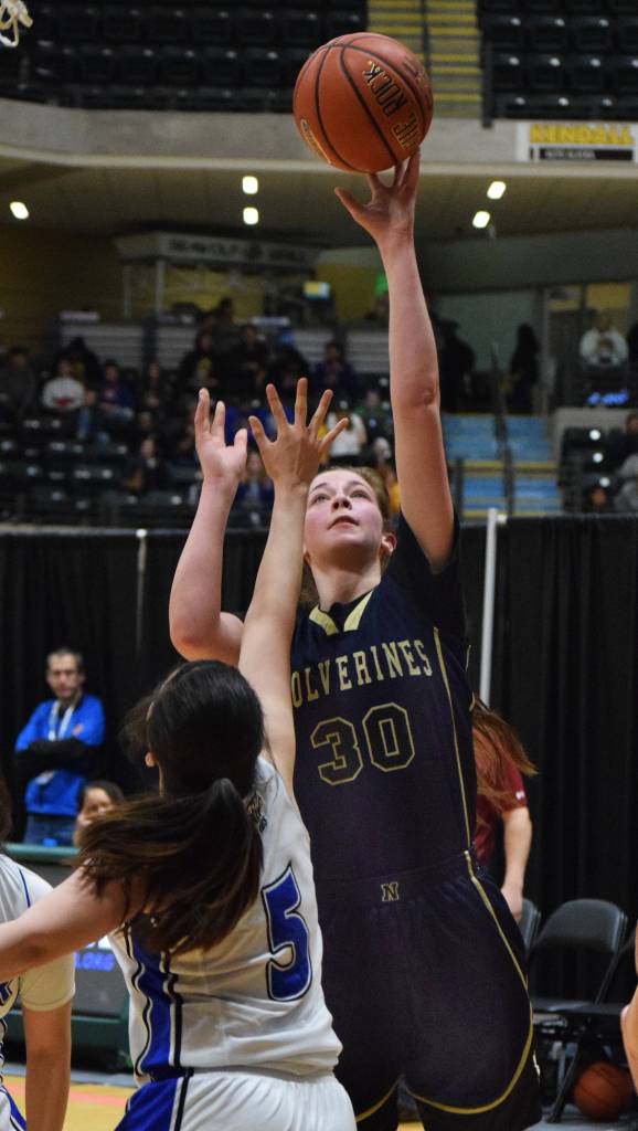 Ninilchik&rsquo;s DeeAnn White puts up a layup over Selawik&rsquo;s Laura Ramoth (5) Wednesday in an opening round contest at the Class 1A state basketball tournament at the Alaska Airlines Center in Anchorage. (Photo by Joey Klecka/Peninsula Clarion)