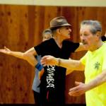 Zumba instructor Truman Krogel (center) leads a class at the Kenai Recreation Center on Thursday, March 15, 2018 in Kenai, Alaska. Krogel, 74, said he first tried Zumba himself four years ago, loved it and began teaching classes of his own in January 2017. (Photo by Elizabeth Earl/Peninsula Clarion)