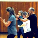 Zumba instructor Truman Krogel (center) leads a class at the Kenai Recreation Center on Thursday, March 15, 2018 in Kenai, Alaska. Krogel, 74, said he first tried Zumba himself four years ago, loved it and began teaching classes of his own in January 2017. (Photo by Elizabeth Earl/Peninsula Clarion)