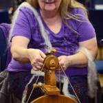 Debora Meester adjusts the bobbin of a spinning wheel while spinning wool into yarn during the first session of the Soldotna Community Schools yarn-spinning class on Tuesday in the library of the Soldotna Preparatory School in Soldotna. (Ben Boettger/Peninsula Clarion)
