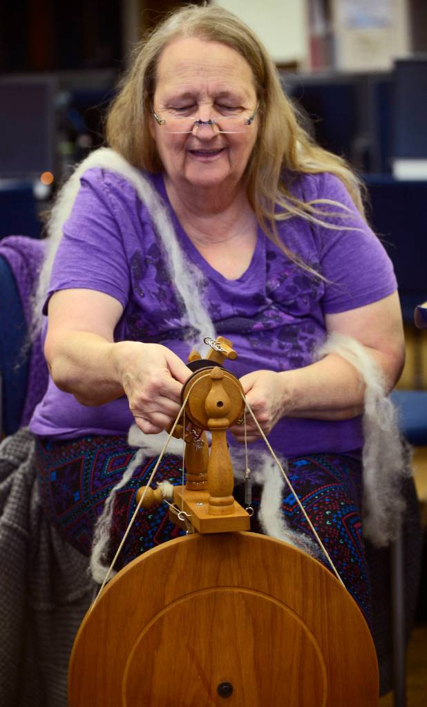Debora Meester adjusts the bobbin of a spinning wheel while spinning wool into yarn during the first session of the Soldotna Community Schools yarn-spinning class on Tuesday in the library of the Soldotna Preparatory School in Soldotna. (Ben Boettger/Peninsula Clarion)