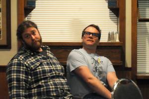 Chris Pepper (right) and Shaylon Cochran (left) stare into the distance during a rehearsal for Triumvirate Theatre&rsquo;s production of &ldquo;Forrest Guppy&rdquo; on Tuesday, March 20, 2018 in Soldotna, Alaska. Pepper plays Forrest Guppy, a parody of the main character from the classic film &ldquo;Forrest Gump,&rdquo; in the comedy parody of the film. The theater troupe last put on the dinner theater production in 2010. (Photo by Elizabeth Earl/Peninsula Clarion)