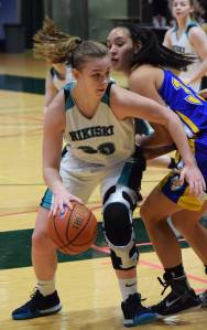 Nikiski&rsquo;s Bethany Carstens makes a move around Kotzebue&rsquo;s Alanna Conwell Friday at the Class 3A state tournament at the Alaska Airlines Center. (Photo by Joey Klecka/Peninsula Clarion)