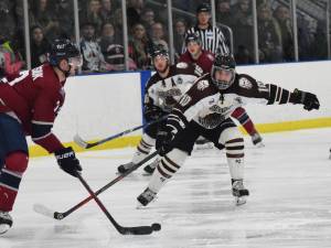 Kenai River skater Lukas Millen eyes the puck, held by Fairbanks&rsquo; Luke Orysiuk, Friday night at the MTA Events Center in Palmer. (Photo by Joey Klecka/Peninsula Clarion)