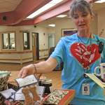 Aud Walaszek, Heritage Place activities coordinator, shows off some of the homemade dog treats baked by residents to fund the purchase of equipment for the Snoezelen room, on March 23 in Soldotna. (Photo by Erin Thompson/Peninsula Clarion)