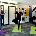 Lisa Wells, center, leads a group of students into tree pose during a yoga class held at Soldotna High School on Friday. (Photo by Kat Sorensen/Peninsula Clarion)