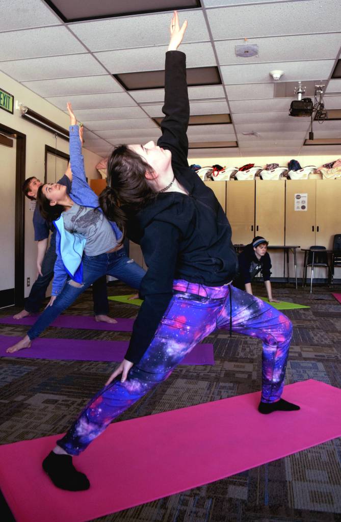 Students practice yoga during the final period of their school day in a class led by Lisa Wells on Friday. (Photo by Kat Sorensen/Peninsula Clarion)