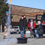 With the push of a button, Owen Walsh (in red) sends a model rocket into the sky, as instructor Scott Aleckson (right) and other students of his rocketry class watch in the parking lot of the Soldotna Regional Sports Complex in Soldotna, Alaska on Saturday, May 31, 2018. Aleckson said he made and launched his first plastic, balsa wood, and cardboard rocket as a 4th grade student at Soldotna Elementary School. Since then he&rsquo;s built a custom launch system, he said, &ldquo;with recycled electronics and a lot of soldering time.&rdquo; Aleckson taught Saturday&rsquo;s rocketry class through the Soldotna Community Schools program, and would like to continue spreading the hobby. &ldquo;If I could get a model rocket club going, that&rsquo;d be great,&rdquo; he said. &ldquo;Stuff like this is much more fun in a group.&rdquo; (Photo by Ben Boettger/Peninsula Clarion)