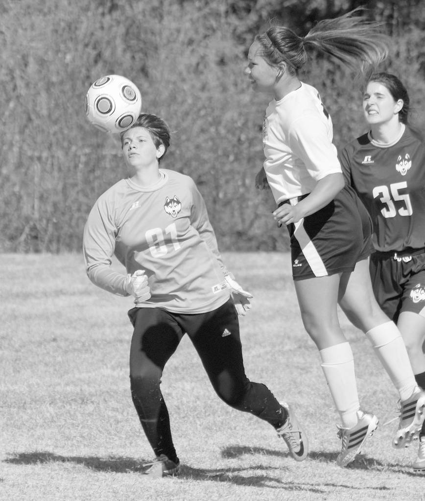 Nikiski&rsquo;s Deidra Lamping heads the ball wide of the goal as Redington goalie Grace Rushing and defender Courtney Crocket look on May 12, 2017, at Nikiski High School. (Photo by Jeff Helminiak/Peninsula Clarion)